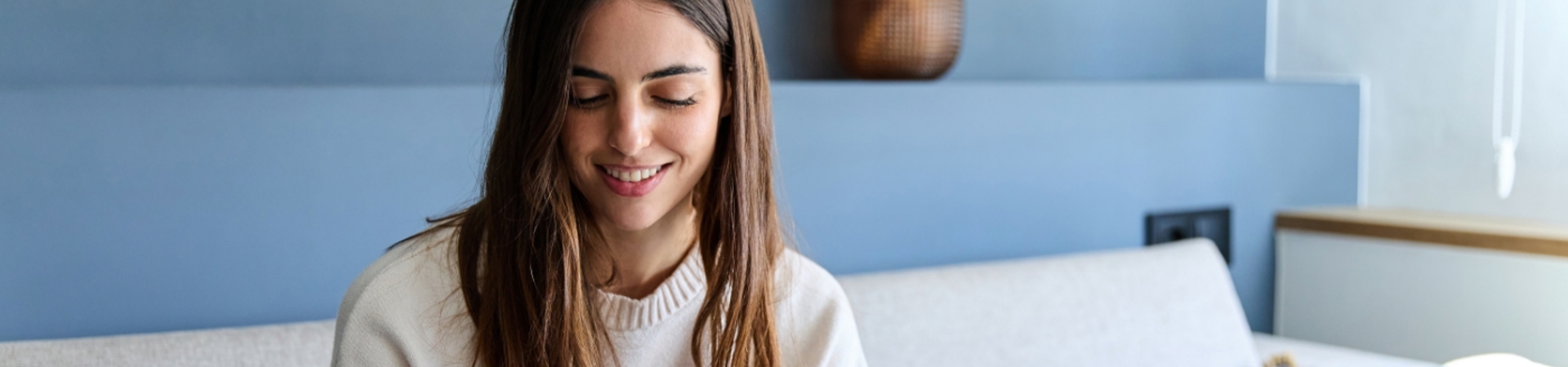 Woman sitting on a sofa entering card details onto a phone